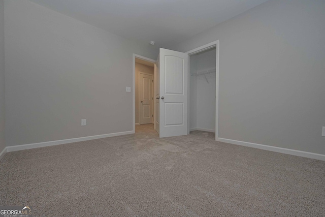 unfurnished bedroom with a closet and light carpet