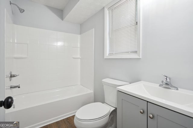 full bathroom with hardwood / wood-style floors, vanity, toilet, and tub / shower combination