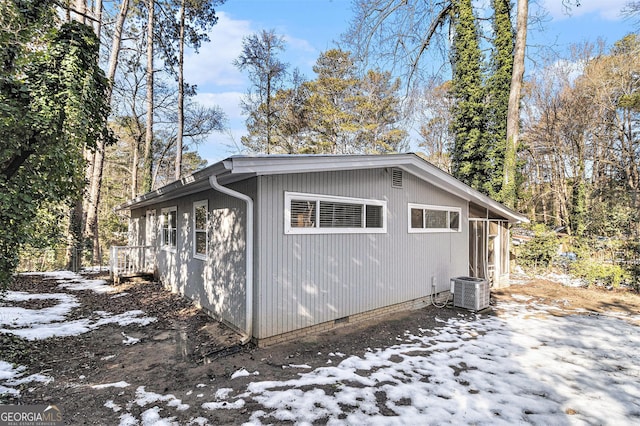 view of snow covered exterior featuring central AC