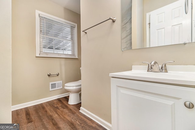 bathroom with toilet, vanity, and hardwood / wood-style flooring