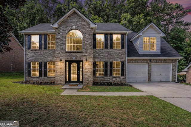 colonial inspired home featuring a lawn and a garage