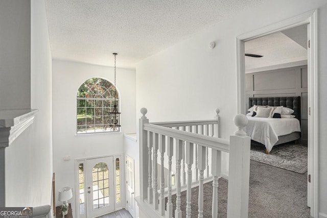 hallway featuring carpet floors and a textured ceiling