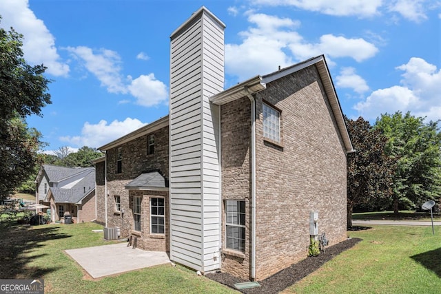 exterior space with a lawn, central air condition unit, and a patio