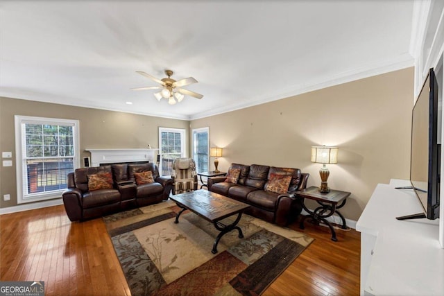 living room featuring ceiling fan, ornamental molding, and wood-type flooring