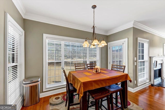 dining area featuring crown molding, dark hardwood / wood-style floors, and a chandelier