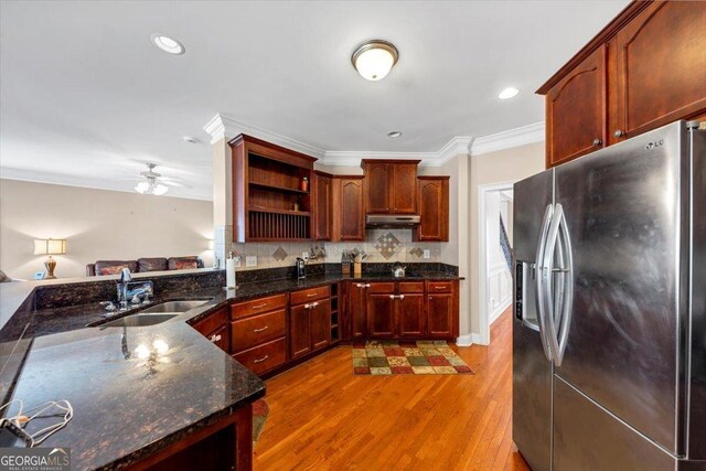 kitchen with hardwood / wood-style floors, sink, stainless steel fridge, kitchen peninsula, and crown molding