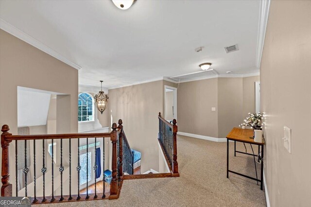 hall featuring ornamental molding, carpet, and a notable chandelier