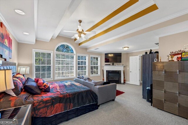 carpeted bedroom with beam ceiling, a high end fireplace, ornamental molding, and ceiling fan