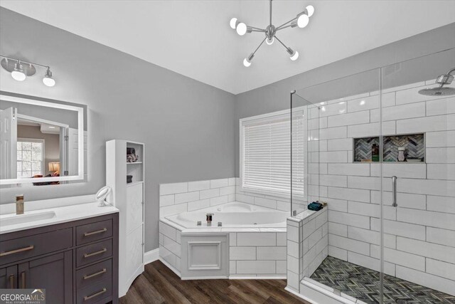 bathroom with wood-type flooring, shower with separate bathtub, and vanity