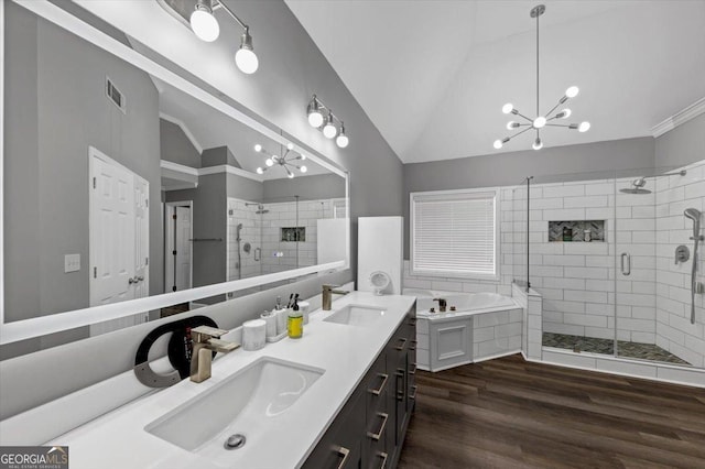 bathroom with hardwood / wood-style flooring, vaulted ceiling, vanity, and a chandelier