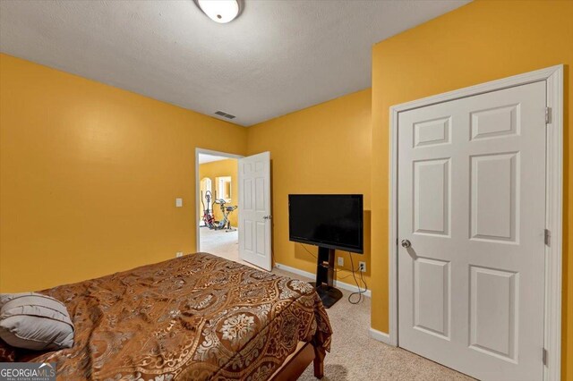 carpeted bedroom with a textured ceiling