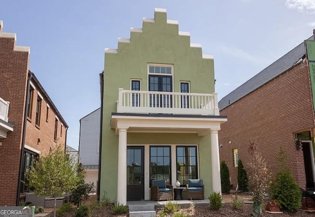 back of house featuring a balcony and a porch