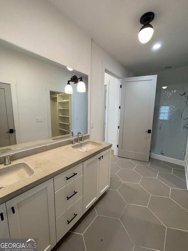 bathroom featuring tile patterned flooring, vanity, and walk in shower