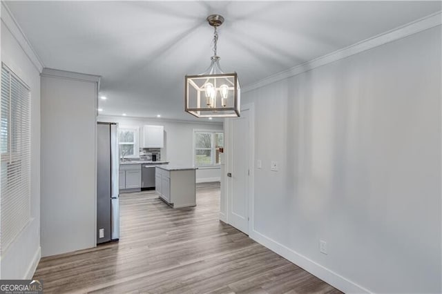 unfurnished dining area with a chandelier, wood-type flooring, and crown molding