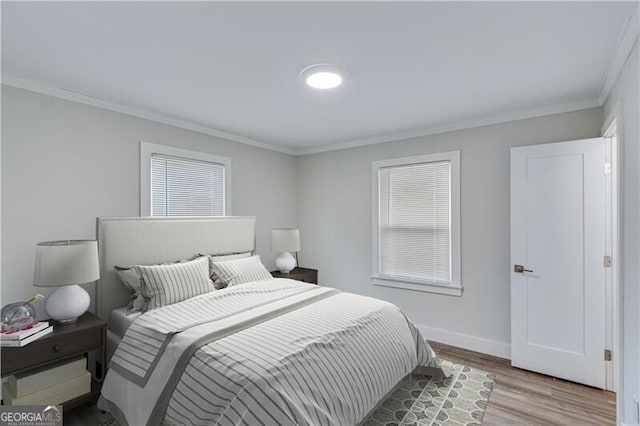 bedroom with crown molding and light wood-type flooring