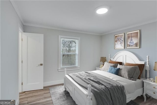 bedroom with hardwood / wood-style floors and crown molding