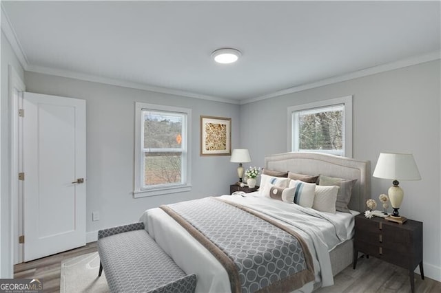 bedroom with hardwood / wood-style flooring, multiple windows, and crown molding