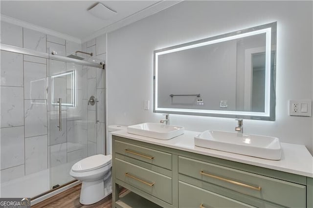 bathroom with walk in shower, wood-type flooring, toilet, vanity, and ornamental molding