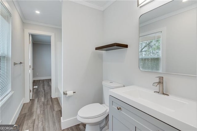 bathroom featuring hardwood / wood-style flooring, vanity, toilet, and crown molding