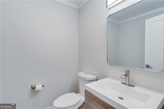 bathroom with crown molding, vanity, and toilet