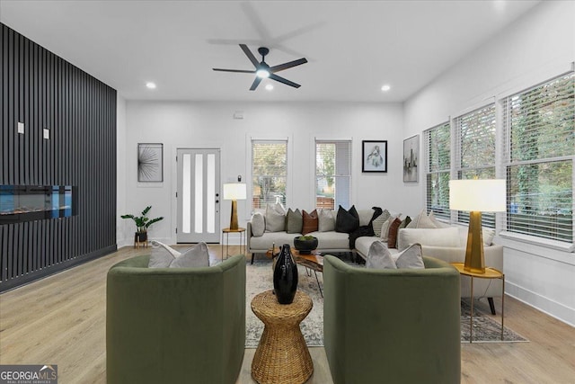 living room with ceiling fan and light hardwood / wood-style flooring