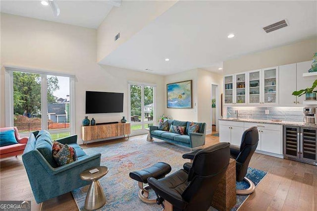 living room with light wood-type flooring and beverage cooler