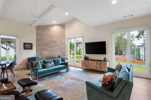 living room featuring ceiling fan, light hardwood / wood-style floors, and lofted ceiling with beams