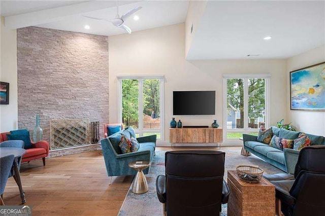 living room featuring ceiling fan, light hardwood / wood-style floors, plenty of natural light, and a fireplace