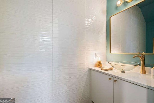 bathroom featuring vanity and tile walls