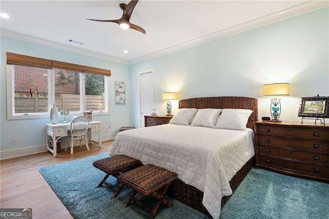 bedroom with ceiling fan, crown molding, and light hardwood / wood-style flooring