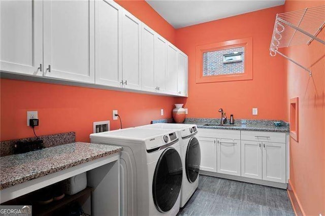 washroom with cabinets, dark hardwood / wood-style flooring, washer and dryer, and sink