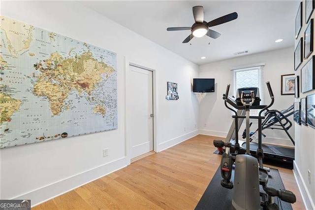 exercise area with ceiling fan and wood-type flooring