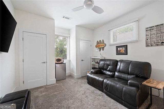 carpeted living room featuring a wealth of natural light and ceiling fan