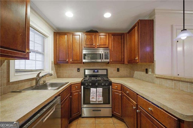 kitchen with decorative backsplash, appliances with stainless steel finishes, sink, pendant lighting, and light tile patterned flooring