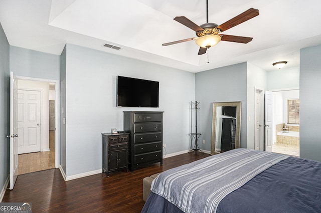 bedroom featuring dark hardwood / wood-style floors, ceiling fan, and ensuite bath