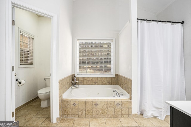 bathroom with vanity, toilet, vaulted ceiling, and tiled tub