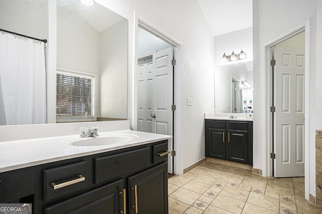 bathroom featuring vaulted ceiling and vanity