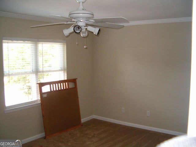 unfurnished room with dark colored carpet, crown molding, and a wealth of natural light