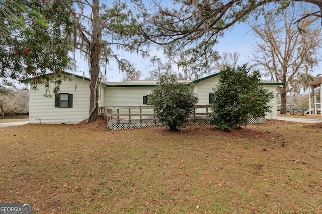 view of home's exterior with a yard and a deck