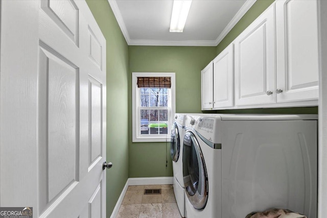 laundry room featuring washing machine and clothes dryer, crown molding, and cabinets