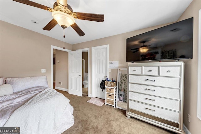 carpeted bedroom featuring ceiling fan and ensuite bath