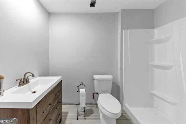 bathroom featuring a shower, vanity, and toilet