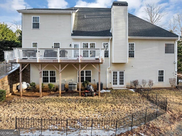 back of property with cooling unit, a wooden deck, and french doors