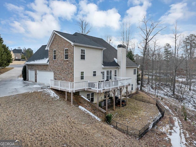 snow covered rear of property featuring a deck