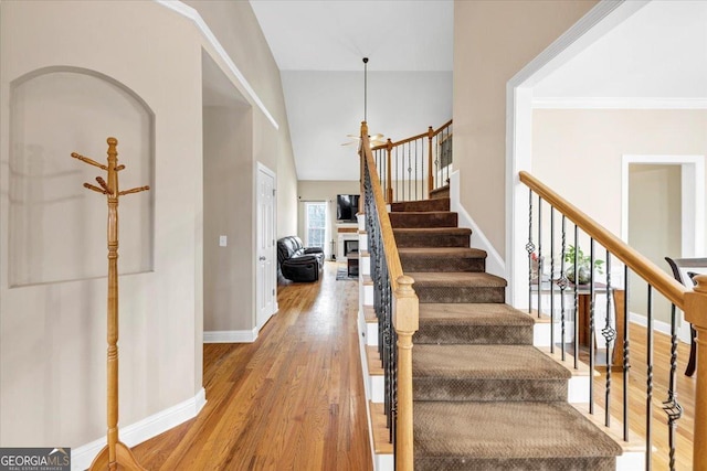 stairs featuring hardwood / wood-style floors, ceiling fan, and vaulted ceiling