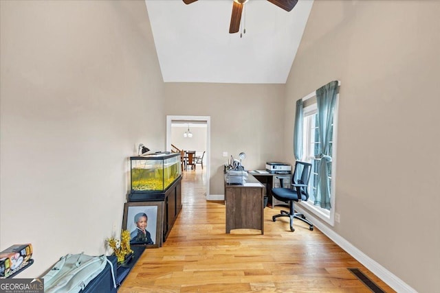 office featuring ceiling fan, light hardwood / wood-style floors, and high vaulted ceiling