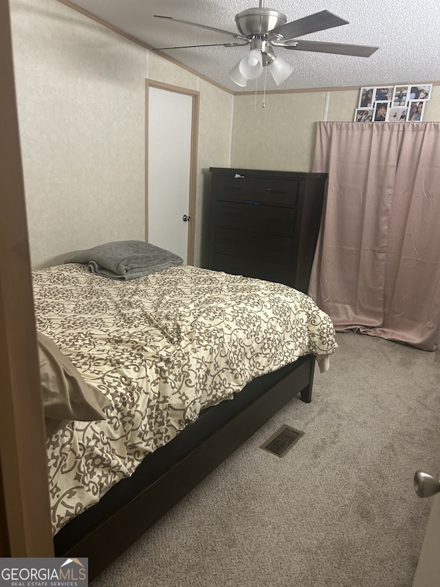 carpeted bedroom featuring ceiling fan, crown molding, and a textured ceiling