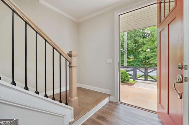 foyer featuring ornamental molding and light wood-type flooring