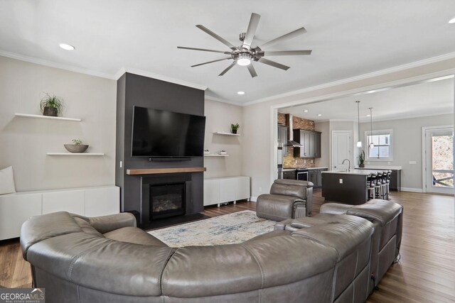 unfurnished living room featuring ornamental molding, ceiling fan, and hardwood / wood-style flooring