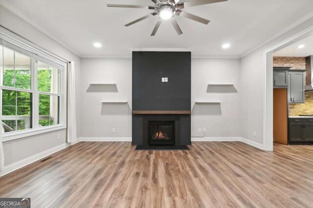 unfurnished living room with light wood-type flooring, ceiling fan, and crown molding